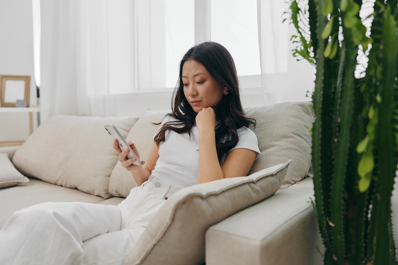 bigstock-A-Young-Asian-Woman-Sits-At-Ho-460886705-1